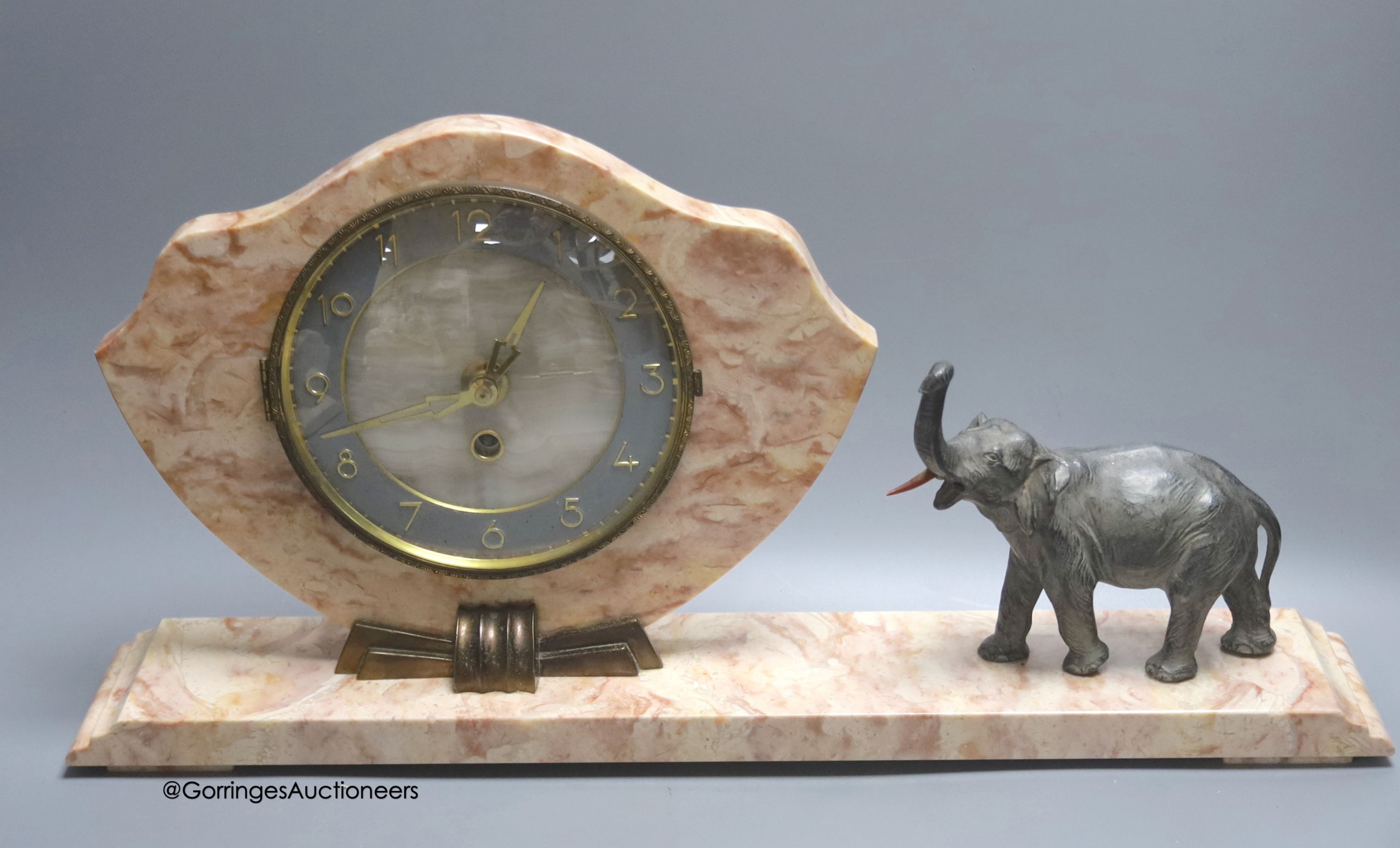 An Art Deco style pink marble 'elephant' clock garniture, length of middle piece 50cm